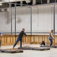 Alumni throwing the football across the room at the Fowling Fun Event